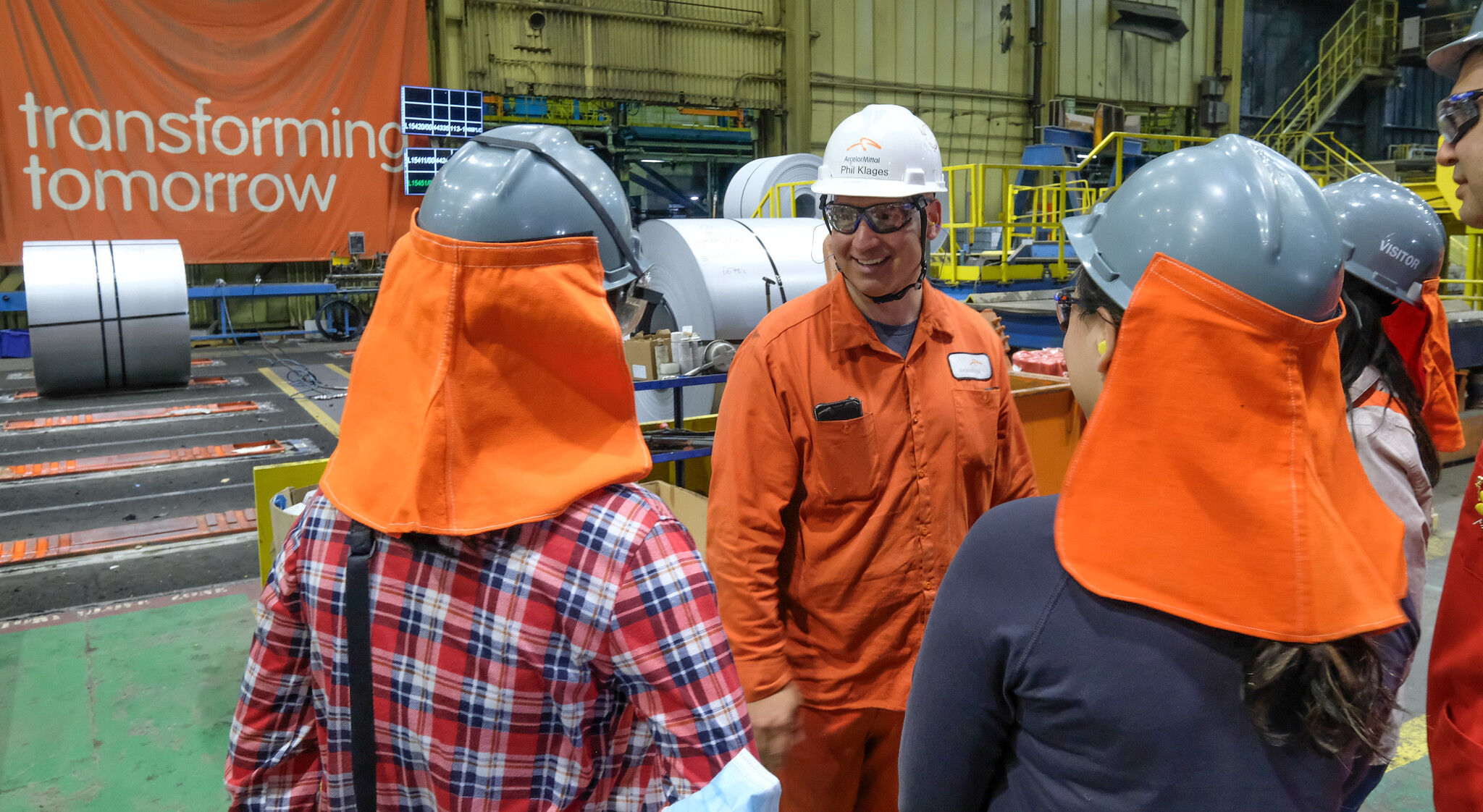 Employee chats with teachers inside of plant