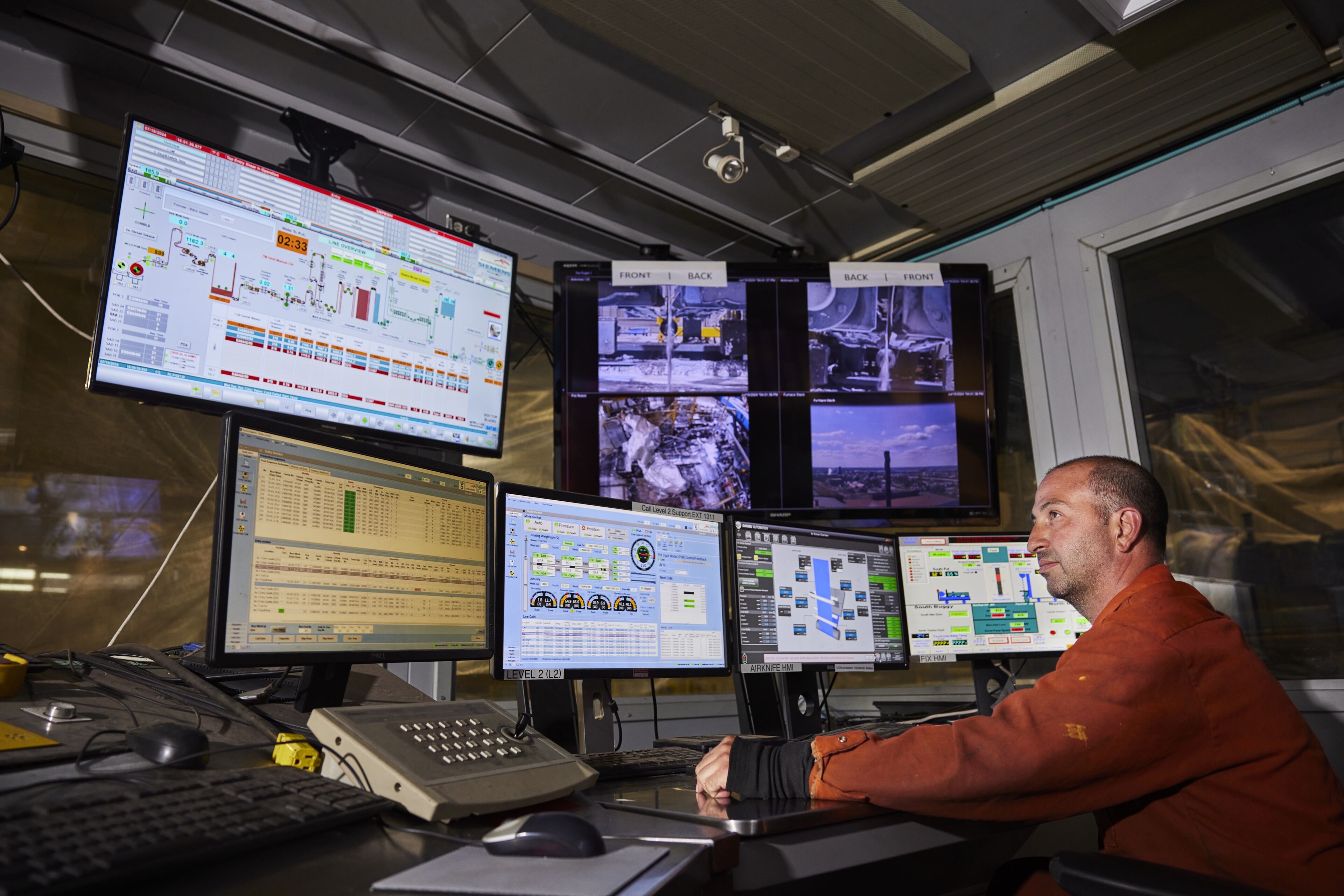 Dofasco employee looks at several monitors