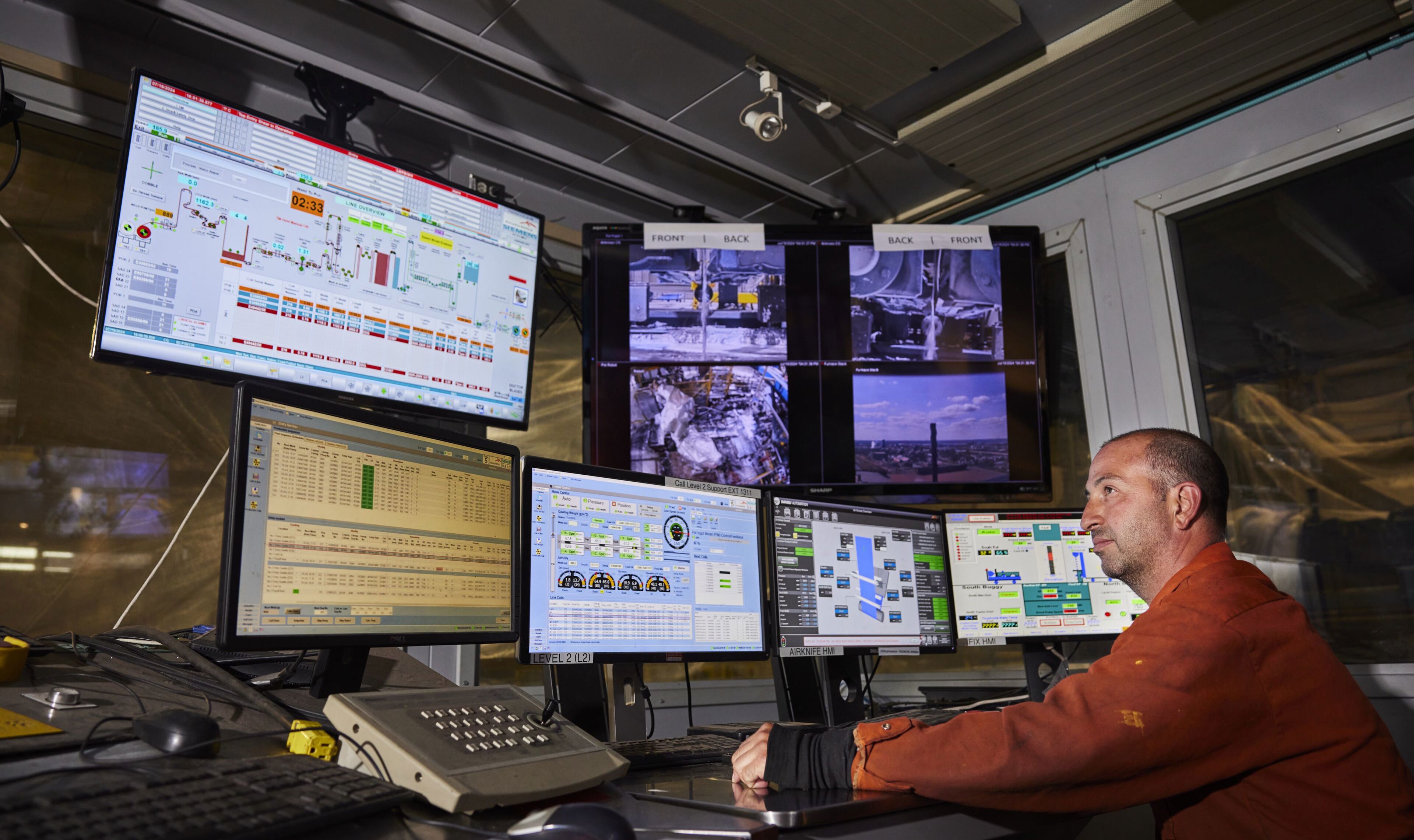 Dofasco employee looks at several monitors