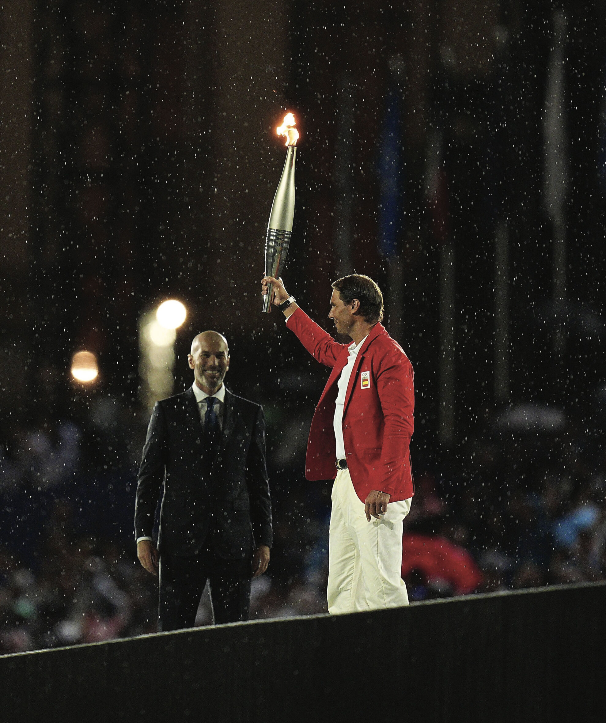 A torchbearer holding the Olympic flame aloft