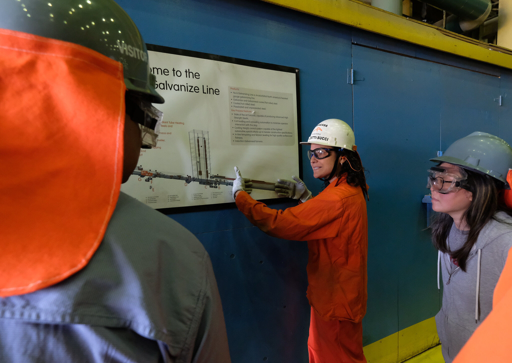 Employee discusses steelmaking process with teachers